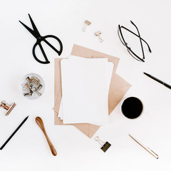 Workspace with clean paper blank, coffee, craft envelope, scissors, office supplies on white background. Flat lay, top view office table desk.