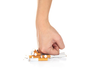 Human hand crushing cigarettes on white background