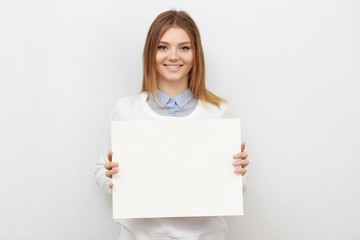Young smiling woman show blank card or paper