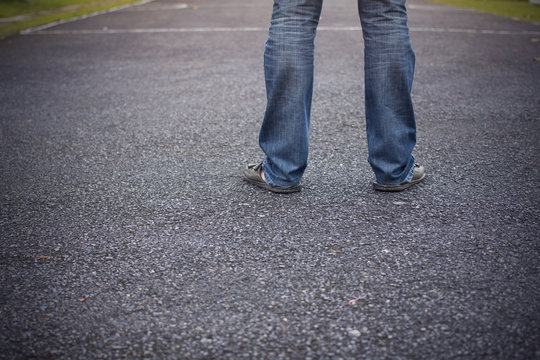 man feet standing on the asphalt concrete floor.