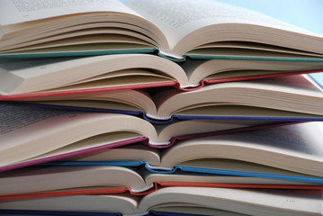 Pile of books with an open book like a background