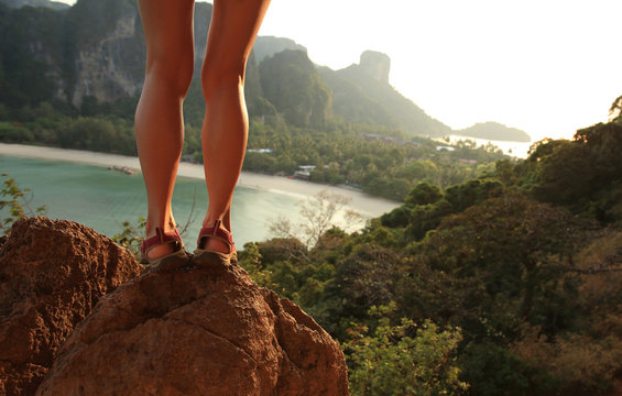 successful woman hiker legs enjoy the view on mountain rock