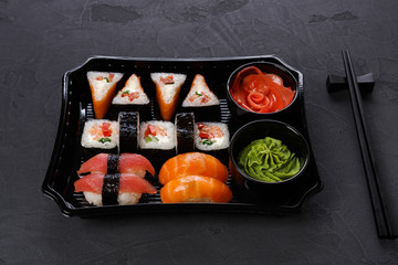 Set of sushi maki and rolls closeup in delivery box