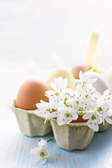 Easter eggs with spring flowers on light background. Copy space,selective focus. Easter photo concept