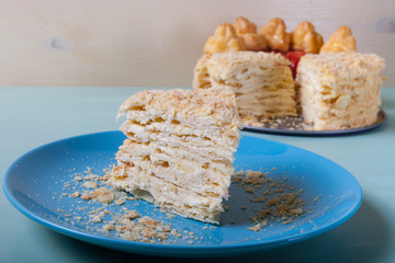 Homemade puff cake with brewed creamy cakes as decor on a light background. Shallow depth of field. Selective focus