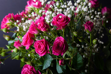 Wonderful bouquet of bush roses and gypsophila on a dark background. Selective focus. Shallow depth of field