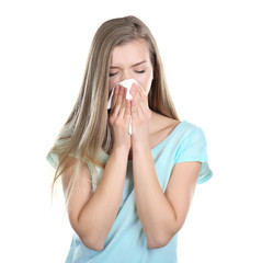 Young woman blowing nose on tissue against white background