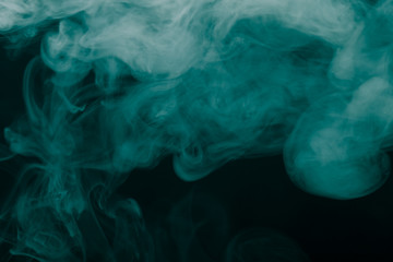 Cloud of smoke on black background. Selective focus. Toned