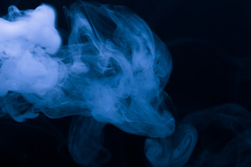 Cloud of smoke on black background. Selective focus. Toned