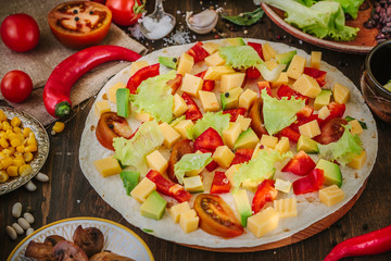 Tortilla with salad over it, surrounded by ingredients.