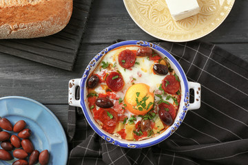Bowl with Spanish baked egg and napkin on kitchen table