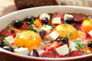 Baking dish with tasty Spanish baked eggs, closeup