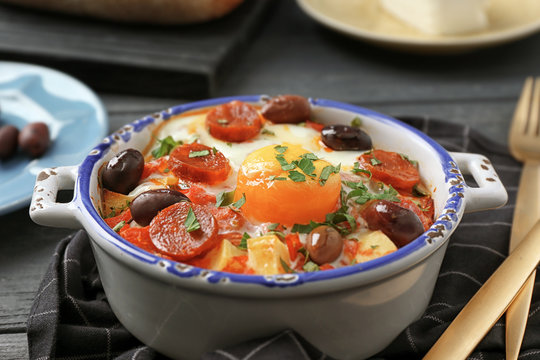 Bowl with Spanish baked egg and napkin on kitchen table