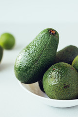 Fresh organic avocado in white ceramic bowl.