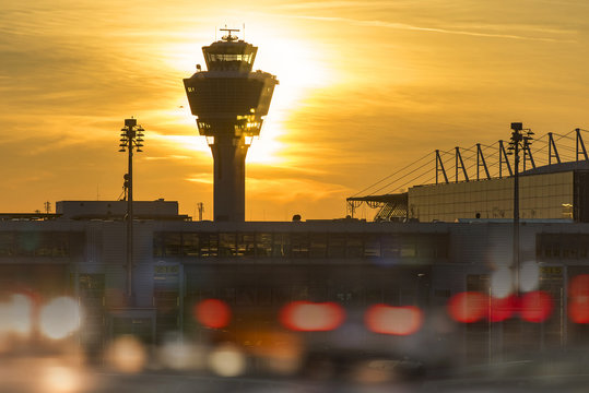 Silhouette of Airport control tower at Munich airport during colorful sunset over city, Germany