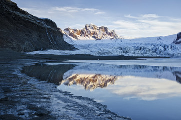 Vatnajökull, Vatna Glacier in Iceland - mountains in sunrise light and dark winter lake