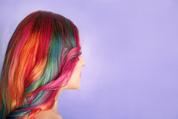 Concept de coiffure à la mode. Jeune femme aux cheveux teints colorés sur fond de couleur