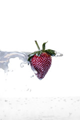 Strawberry fruit with milk splash on white background