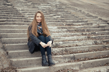 Portrait of a beautiful girl in early spring on the steps