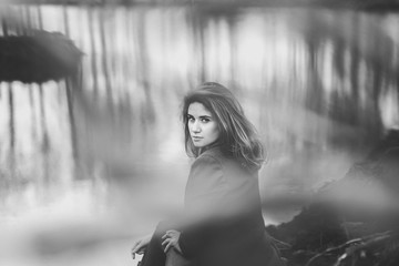  Conceptual black and white portrait of a woman sitting on the river bank  - 143028773