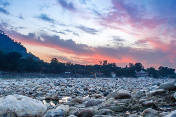 View of River Ganga and lots of stones after sunset with amazing dramatic sky. Rishikesh. India.