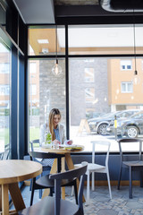 Beautiful Young Woman Sitting in Coffee Shop