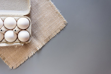 Cardboard egg rack with eggs on gray background. Top view.  Rural still life, natural organic healthy food.