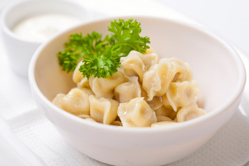 Meat dumplings - russian pelmeni, ravioli with meat in a deep bowl