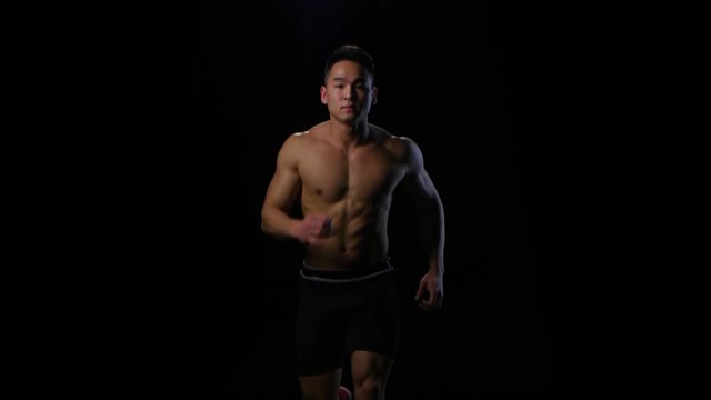 Athlete run on the black background at fast pace. Studio
