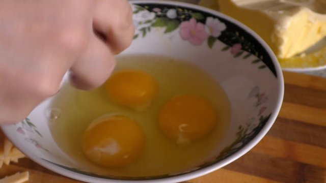Breaking and stir the eggs into the plate. Slow motion
