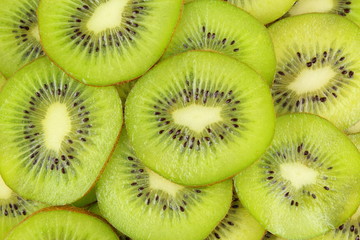slices of fresh green kiwi fruits food background texture