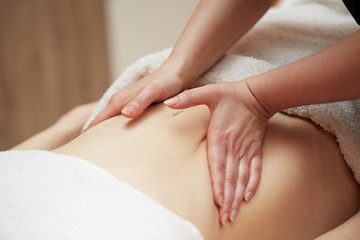 Fototapeta na wymiar beauty, holidays and spa concept - woman in spa salon getting massage