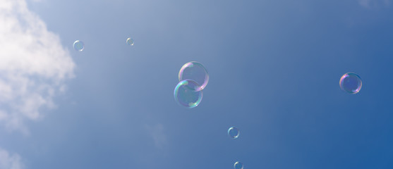Seifenblasen fliegen am blauen Himmel am Tag - Panorama