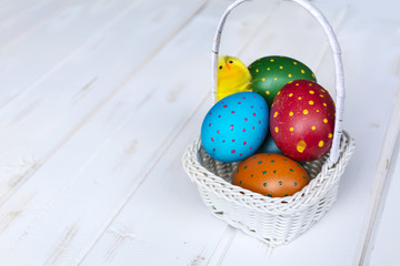 beautiful easter eggs with dots and chicken  in a white basket 
