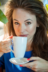 Beautiful young woman holding a cup of coffee. Coffee drinker.