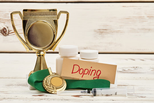 Cup, pills and medal. Reasons for sport disqualification.