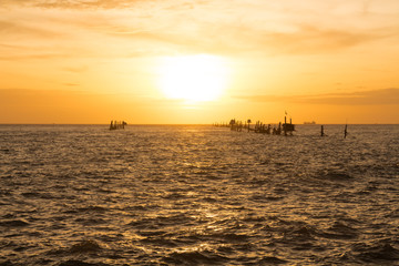 Naklejka na ściany i meble Sunset over the sea and ships in Vietnam