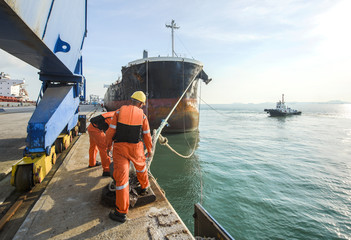 mooring gangs attending to un-berth the ship on sailing departure from the terminal of port