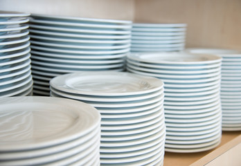 Group of white plates stacked together in a hotel.