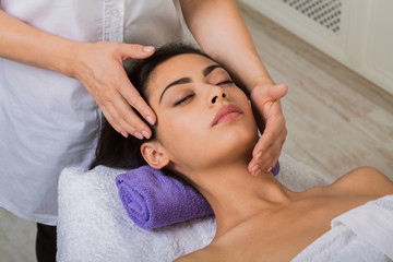Fototapeta na wymiar Woman massagist make face lifting massage in spa wellness center