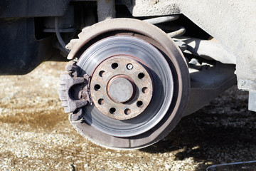 View of a brake system with spoiled brake pads and damaged old rotor