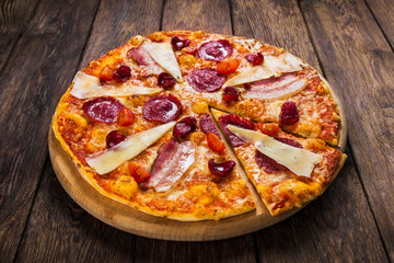 Delicious italian pizza with salami, bacon and parmesan