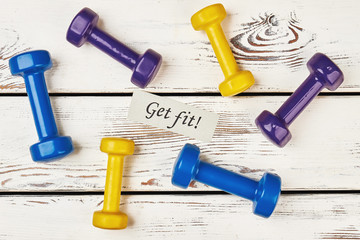 Dumbbells scattered on wooden surface. Physical benefits of sport.