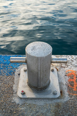 Closeup of a mooring bollard on a jetty by the sea