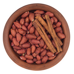 peanuts with cinnamon sticks in a ceramic bowl.