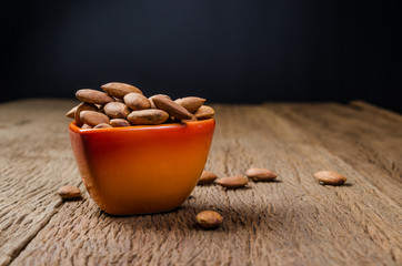 almond in porcelain heart bowl on wooden board