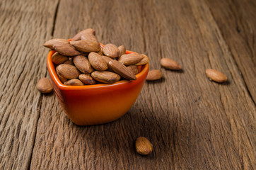 almond in porcelain heart bowl on wooden board