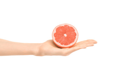 Healthy eating and diet Topic: Human hand holding a half of grapefruit isolated on a white background in the studio