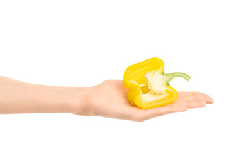 Healthy eating and diet Topic: Human hand holding a half of yellow pepper isolated on a white background in the studio