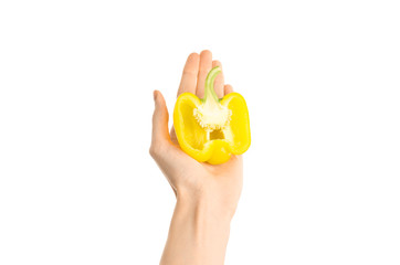 Healthy eating and diet Topic: Human hand holding a half of yellow pepper isolated on a white background in the studio, first-person view